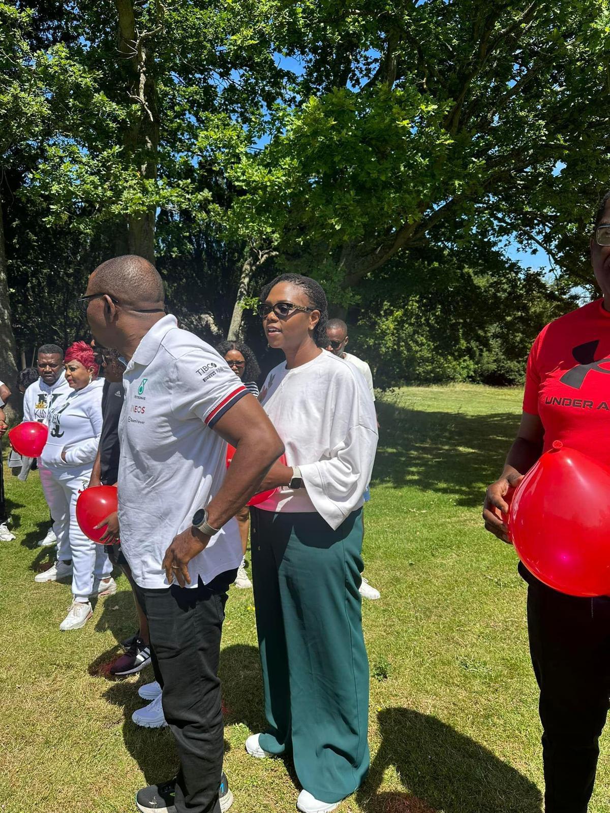 Couples on a walk holding red balloons